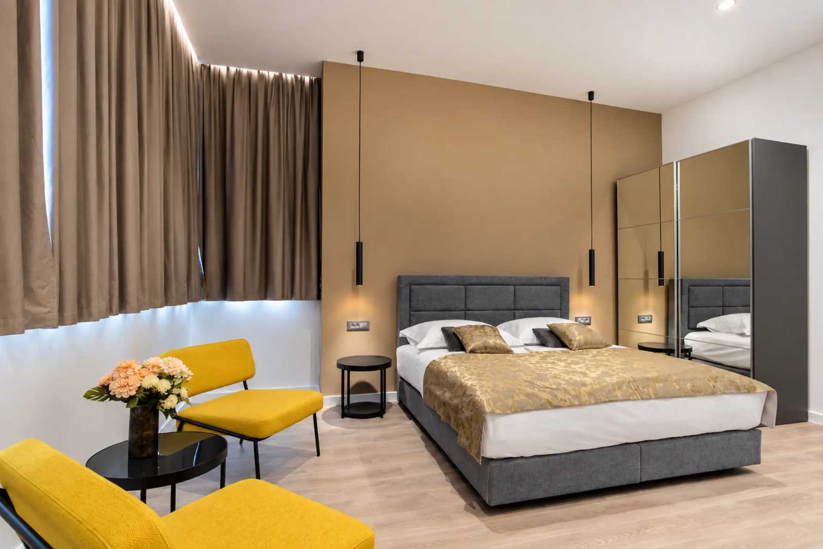 Contemporary guest room interior with queen bed, seating and warm finishes